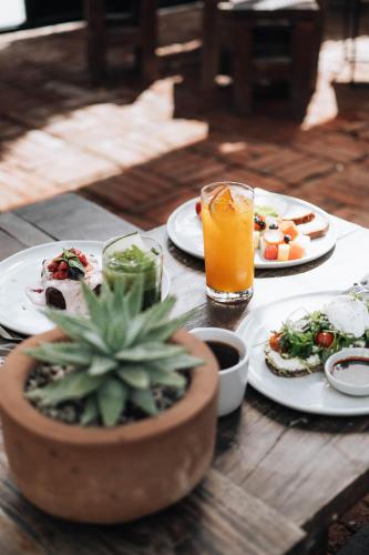 a table with plates of food and a glass of orange juice at Drift San Jose del Cabo, a Member of Design Hotels in San José del Cabo