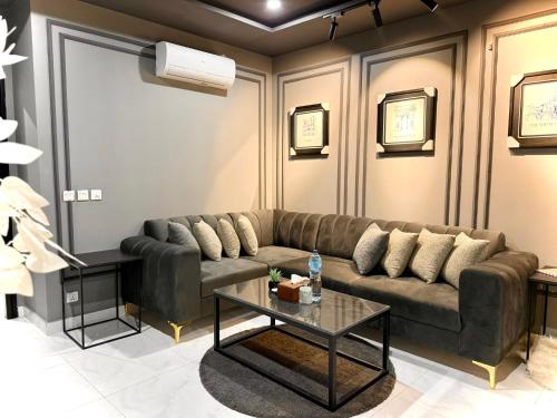 a living room with a couch and a table at Starlit By Zameen Opal in Lahore