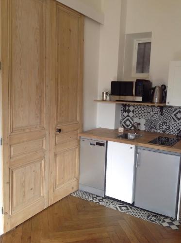 a kitchen with wooden cabinets and a white refrigerator at Cocon au pied de la Croix Rousse in Lyon