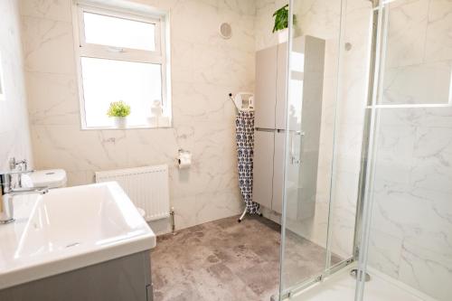 a bathroom with a shower and a sink at Wild Atlantic Way Retreat by Shortstays in Ballynahown