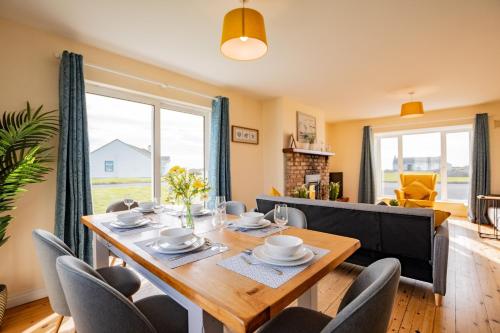 a dining room and living room with a wooden table and chairs at Wild Atlantic Way Retreat by Shortstays in Ballynahown