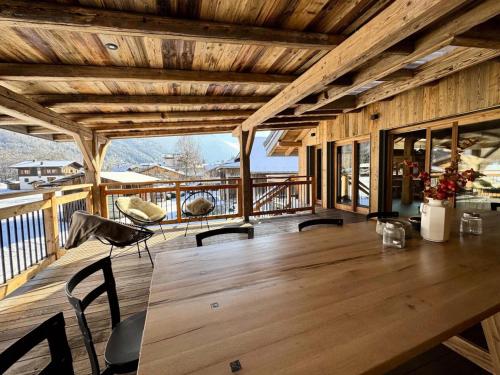 Cette chambre en bois dispose d'une terrasse avec une table et des chaises. dans l'établissement Résidence Plume - Chalet Plume - 14 Personnes - Morzine MAE-3771, à Morzine