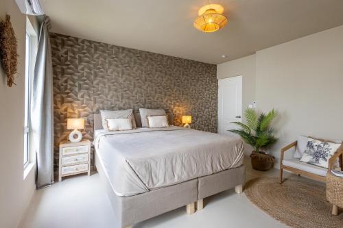 a bedroom with a large bed and a chair at Luxe nieuwbouw villa toplocatie in Jan Thiel in Jan Thiel