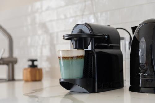 a coffee maker sitting on a kitchen counter with a cup at Luxe nieuwbouw villa toplocatie in Jan Thiel in Jan Thiel