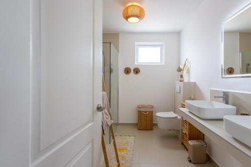 a white bathroom with two sinks and a toilet at Luxe nieuwbouw villa toplocatie in Jan Thiel in Jan Thiel