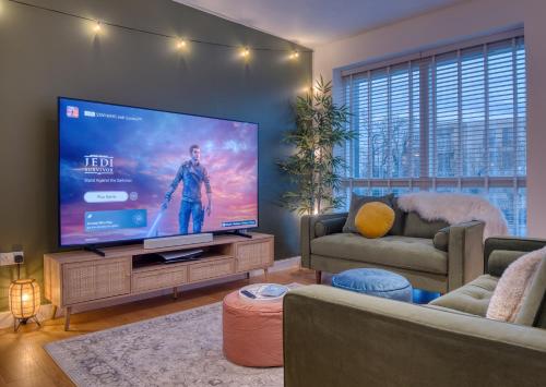 a living room with a large flat screen tv at Cambridge - hot tub, sauna, parking, pool table in Trumpington
