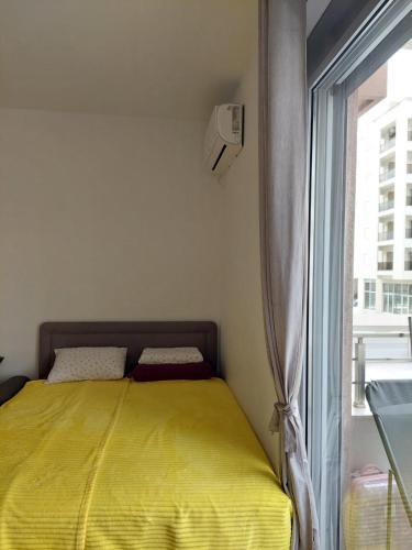 TiN Apartment في أولتسينج: غرفة نوم بها سرير أصفر بجوار نافذة