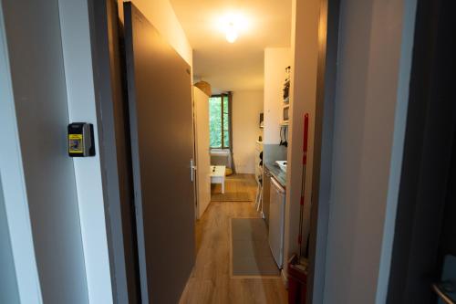 un couloir menant à une cuisine avec un lavabo et des toilettes dans l'établissement Le Petit Brienne - Centre-Ville Aéroport TBS, à Toulouse