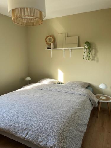 a bedroom with a bed with a blue blanket at Cayeux sur oiseaux in Cayeux-sur-Mer