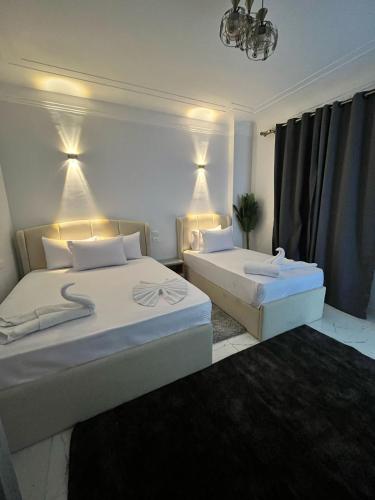 a bedroom with two beds and a chandelier at Triple Garden Studios and apartments in Cairo