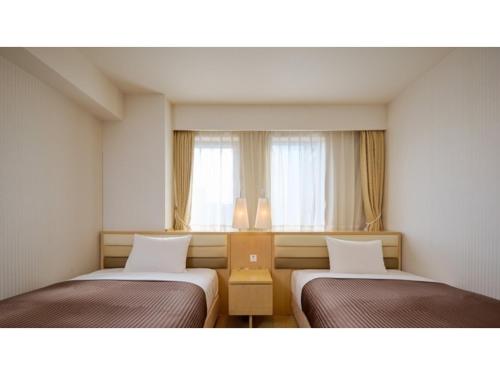 zwei Betten in einem Zimmer mit Fenster in der Unterkunft The OneFive Tokyo Kameido - Vacation STAY 64611v in Tokio