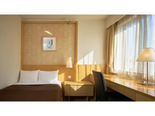 ein Hotelzimmer mit einem Bett, einem Schreibtisch und einem Fenster in der Unterkunft The OneFive Tokyo Kameido - Vacation STAY 64595v in Tokio