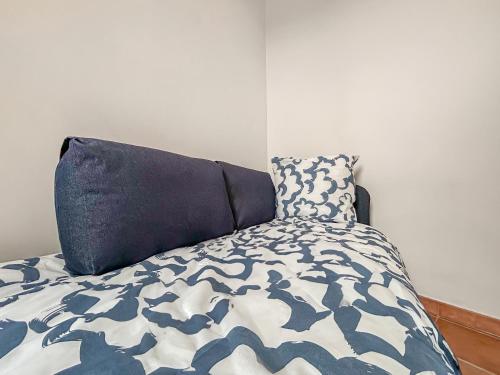 a bed with a blue and white comforter and a pillow at Séjour authentique en plein centre d Avignon in Avignon