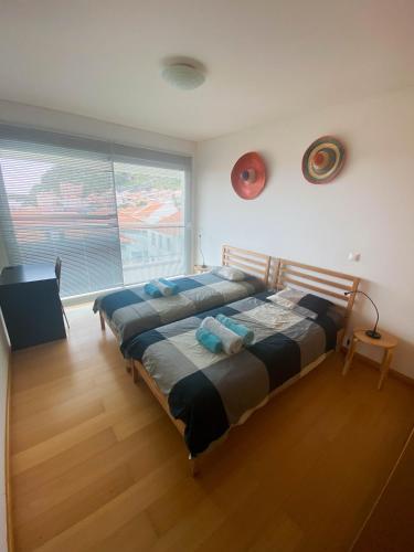 a bedroom with two beds and a large window at Amazing Views in Machico in Machico