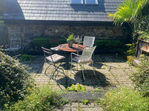 a patio with a table and chairs in a backyard at Beautiful renovated stone house for Dog friendly, Quayside location in Newport
