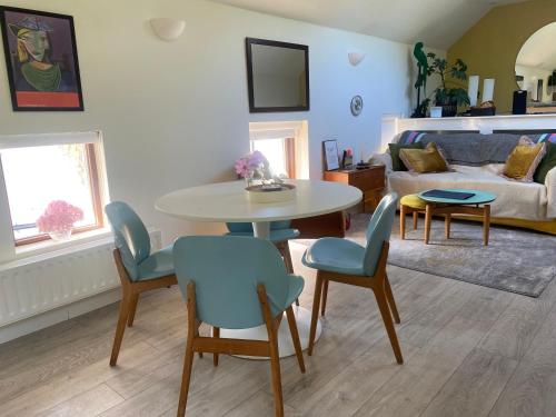 a living room with a table and chairs and a couch at Beautiful renovated stone house for Dog friendly, Quayside location in Newport