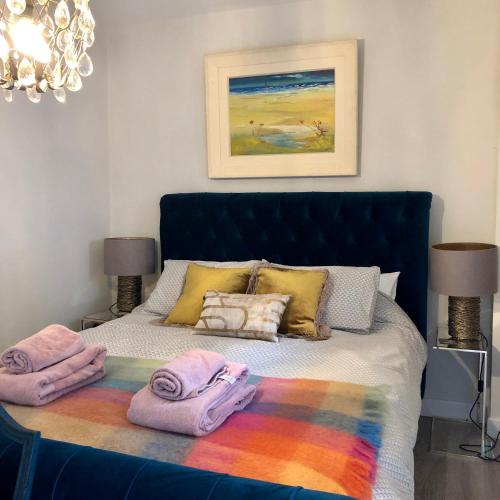 a bedroom with a bed with towels on it at Beautiful renovated stone house for Dog friendly, Quayside location in Newport