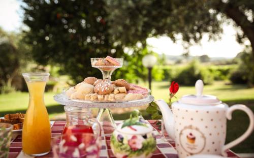 a picnic table with a plate of cookies and a drink at Agriturismo La Vecchia Quercia in Montemerano
