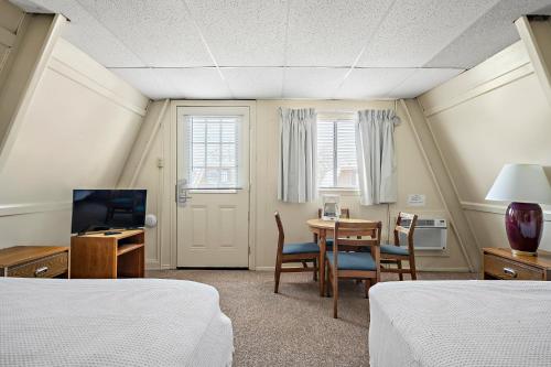 a room with two beds and a table and a television at Heidelberg Lodges in New Braunfels