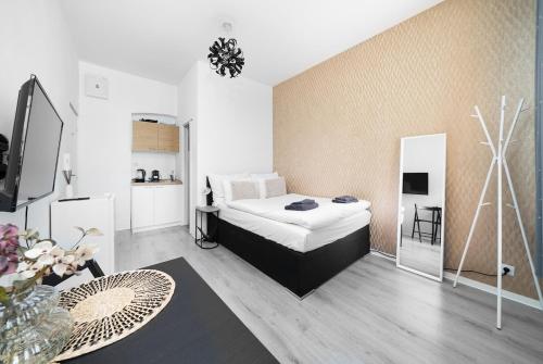 een slaapkamer met een bed, een tafel en een tv bij Cozy studio near city in Praag