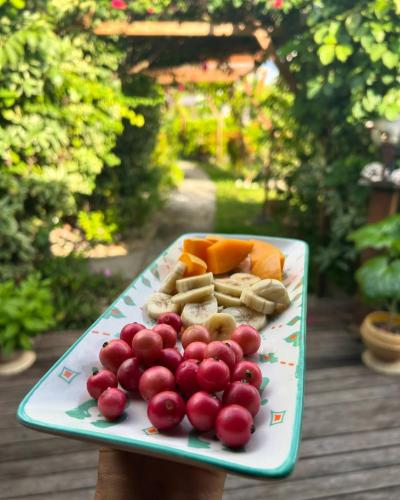 a plate of fruit and vegetables on a table at Pension Bounty Rangiroa - Art Gallery & Tropical Garden in Rangiroa