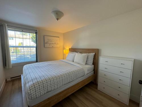 a bedroom with a bed with a dresser and a window at San Dune Inn in Manzanita