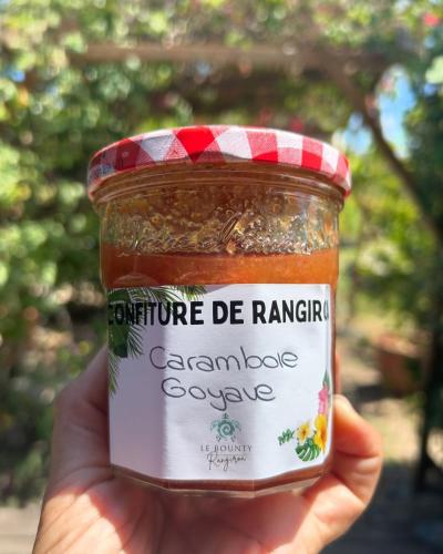 a person holding up a jar of caramole sauce at Pension Bounty Rangiroa - Art Gallery & Tropical Garden in Rangiroa