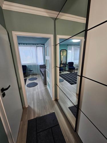 a hallway with a mirror and a living room at Westfield apartment in Prague