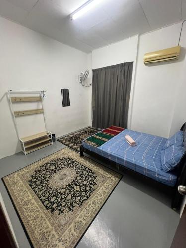 a room with two beds and two rugs on the floor at Cja Homestay Batu Kawan in Simpang Ampat