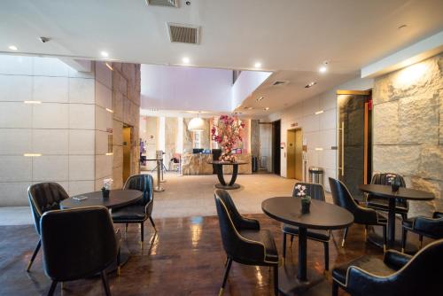 a restaurant with tables and chairs in a room at The One Boutique Hotel in Queens