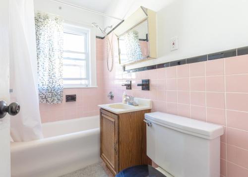 a pink bathroom with a toilet and a sink at Private Cozy Room #6 in Boston