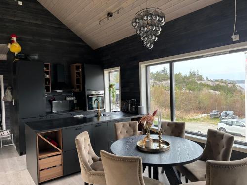 a kitchen with a table and chairs and a large window at Flott hytte på Bersagel nær sjø in Sandnes