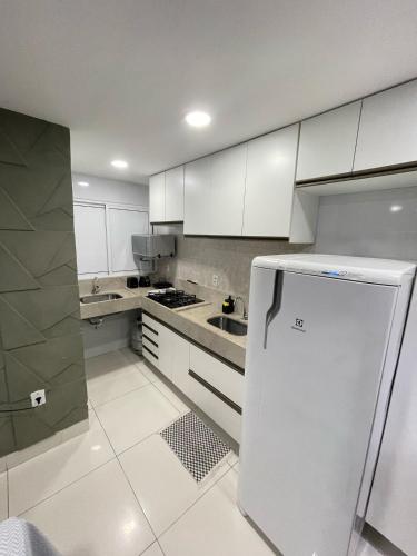 a kitchen with white cabinets and a white refrigerator at Jr flats in João Pessoa