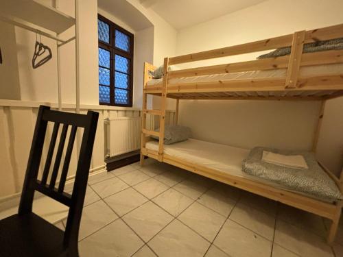 a room with two bunk beds and a chair at Simplex Stays Kraichtal Monteurzimmer in Kraichtal