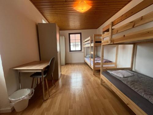 a dorm room with bunk beds and a desk at Simplex Stays Kraichtal Monteurzimmer in Kraichtal