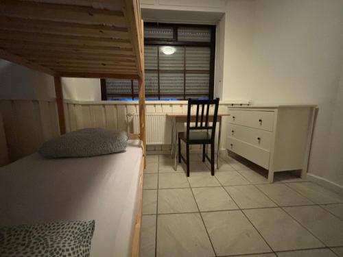 a bedroom with a bed and a desk and a chair at Simplex Stays Kraichtal Monteurzimmer in Kraichtal