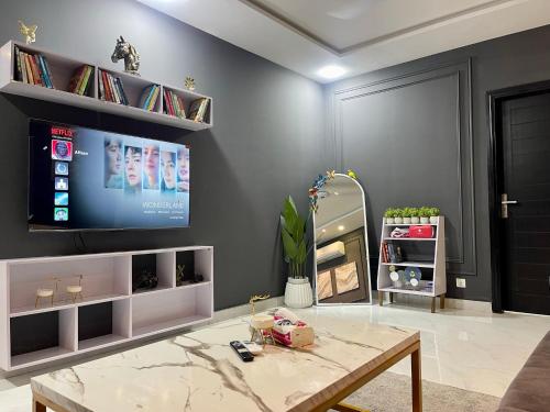 a living room with a tv and a table at Starlit By Zameen Opal in Lahore