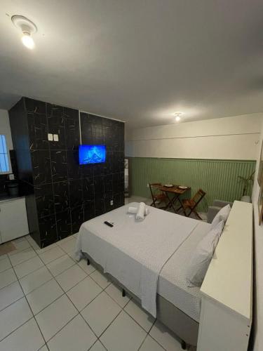 a bedroom with a bed and a tv on a wall at Jr flats in João Pessoa