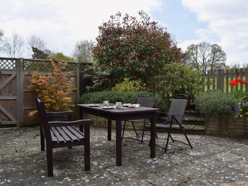 a table and chairs in a garden with a fence at Sunrise in Coughton