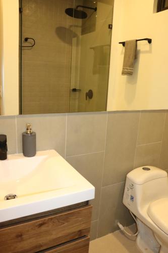 ein Badezimmer mit Waschbecken, Toilette und Spiegel in der Unterkunft apartamento con vista al mar in Santa Marta