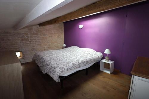 - une chambre avec un mur violet et un lit dans l'établissement Maison Vendée, à Angles