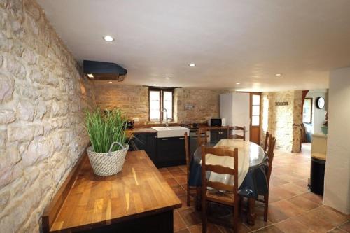 Il comprend une cuisine et un salon avec un mur en pierre. dans l'établissement Maison Vendée, à Angles