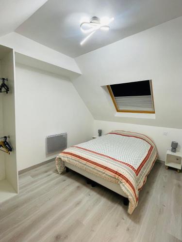 une chambre blanche avec un lit et une télévision à écran plat dans l'établissement Maison centre ville, à Calais