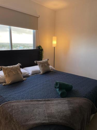 a bedroom with a large bed with a large window at Departamento exclusivo Liverte in Cancún