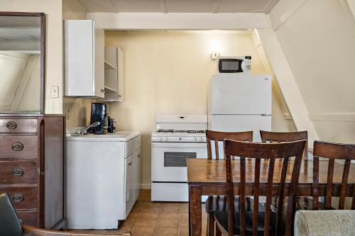 a kitchen with a table and a white refrigerator at Heidelberg Lodges in New Braunfels