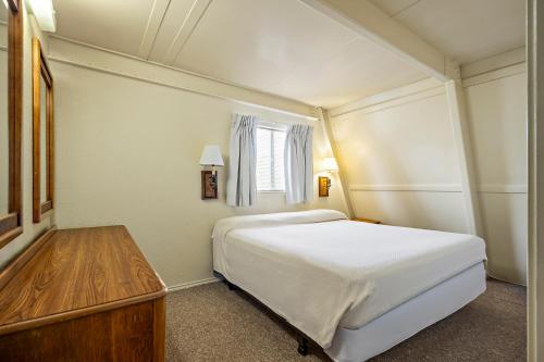a bedroom with a large white bed and a window at Heidelberg Lodges in New Braunfels