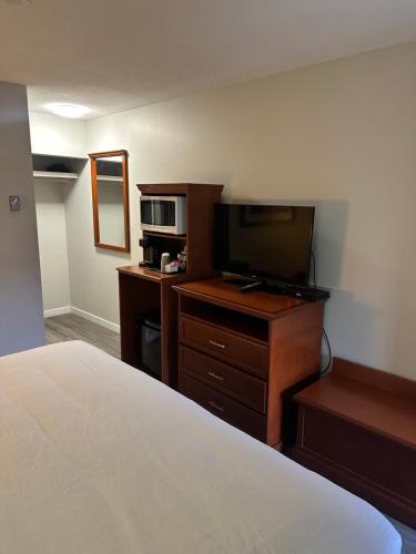 a bedroom with a bed and a tv and a microwave at Travelodge by Wyndham Langley in Langley