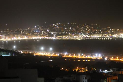 a view of a city at night with lights at 3 Appartements Vue sur Mer dans une maison indépendante in Tangier
