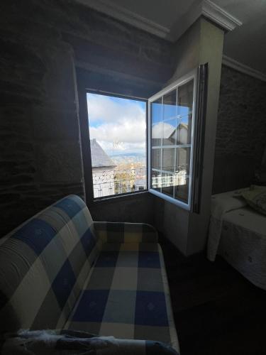 a room with a window and a couch and a bed at Hotel Casa Alberto in Castro Caldelas