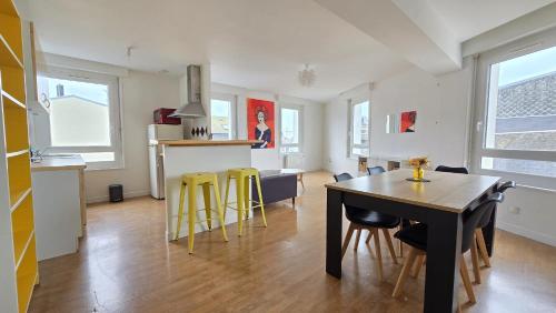 une cuisine et une salle à manger avec une table et des chaises jaunes dans l'établissement Le Voyageur Coucher de soleil vue mer, à Berck-sur-Mer